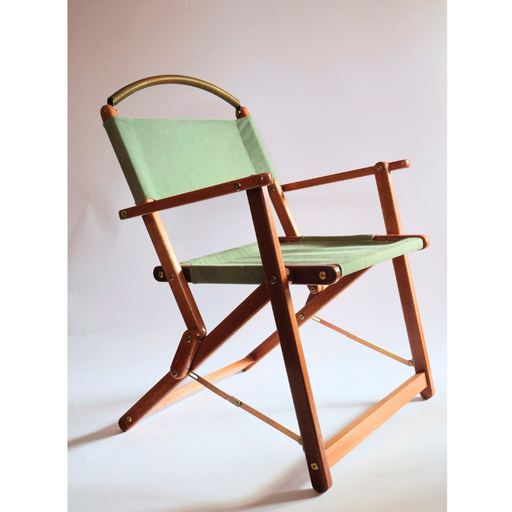 Foldable chair with green seat and wood frame on a white background