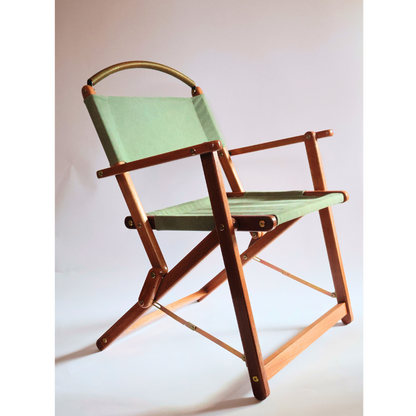 Foldable chair with green seat and wood frame on a white background