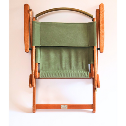 Wooden folding chair with green fabric on a white background